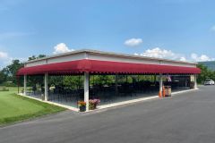 A large, custom-designed awning installed at a golf course, providing shade and enhancing the building